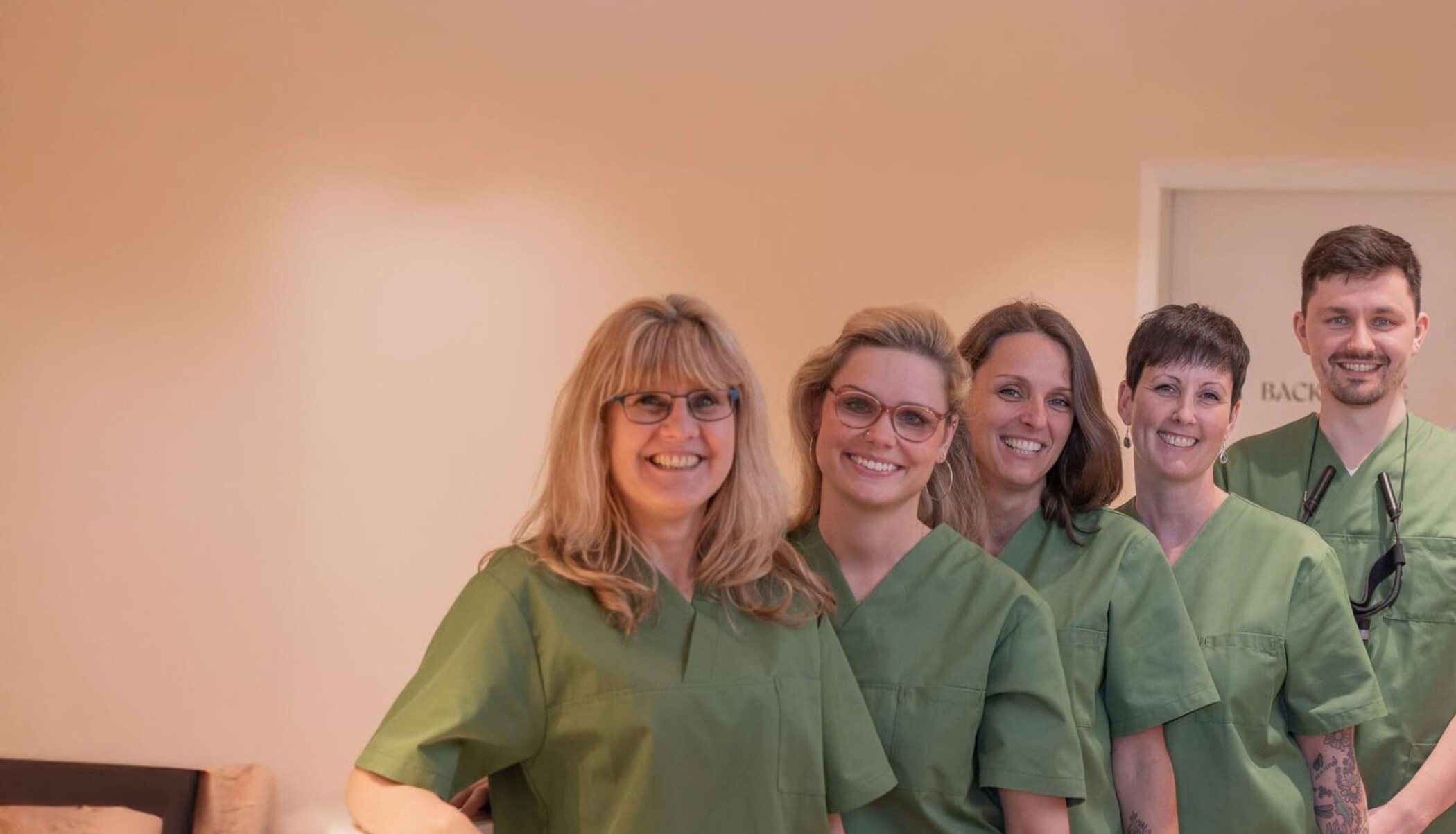 Das gesamte Team des Zentrum f&uuml;r Zahnheilkunde Michendorf steht nebeneinander und l&auml;chelt in die Kamera