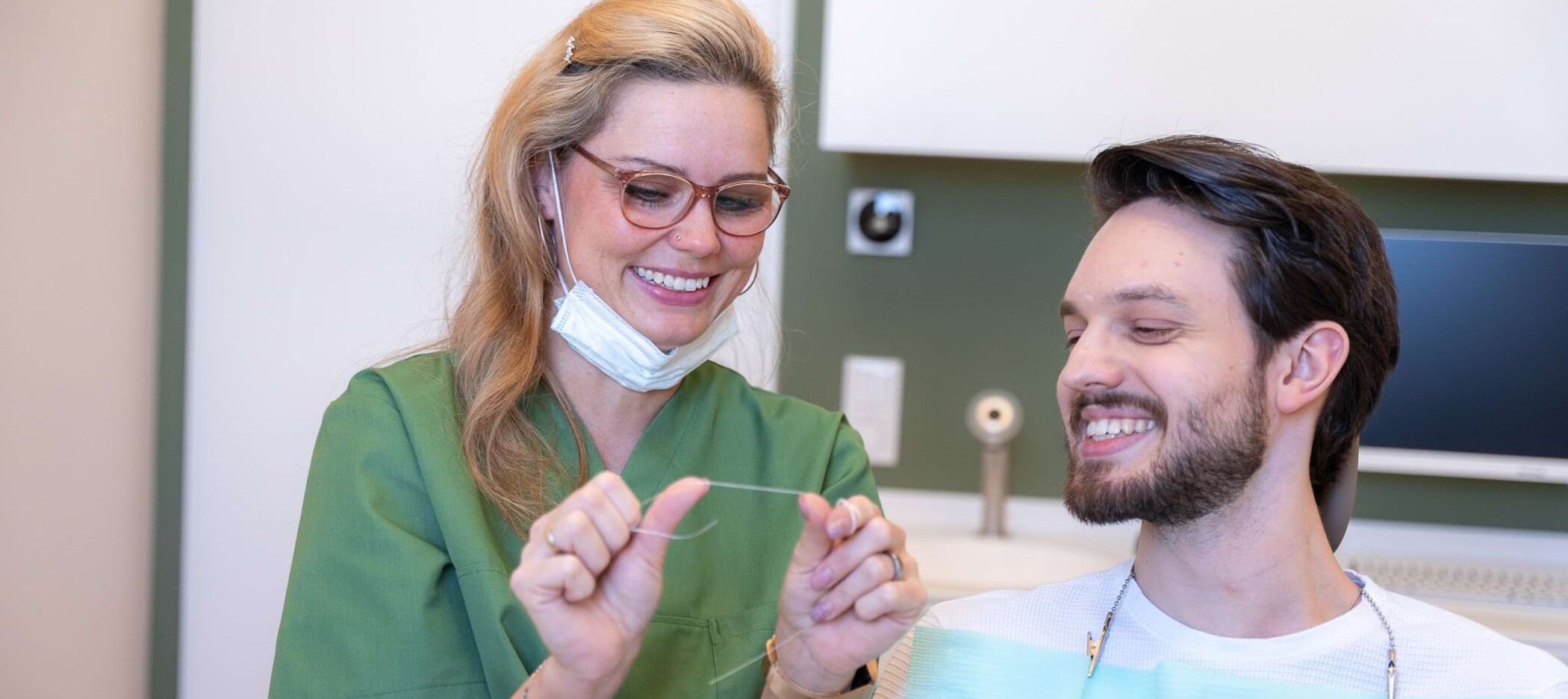 Fotoaufnahme: Mitarbeiterin führt eine Zahnreinigung bei einem Patienten durch