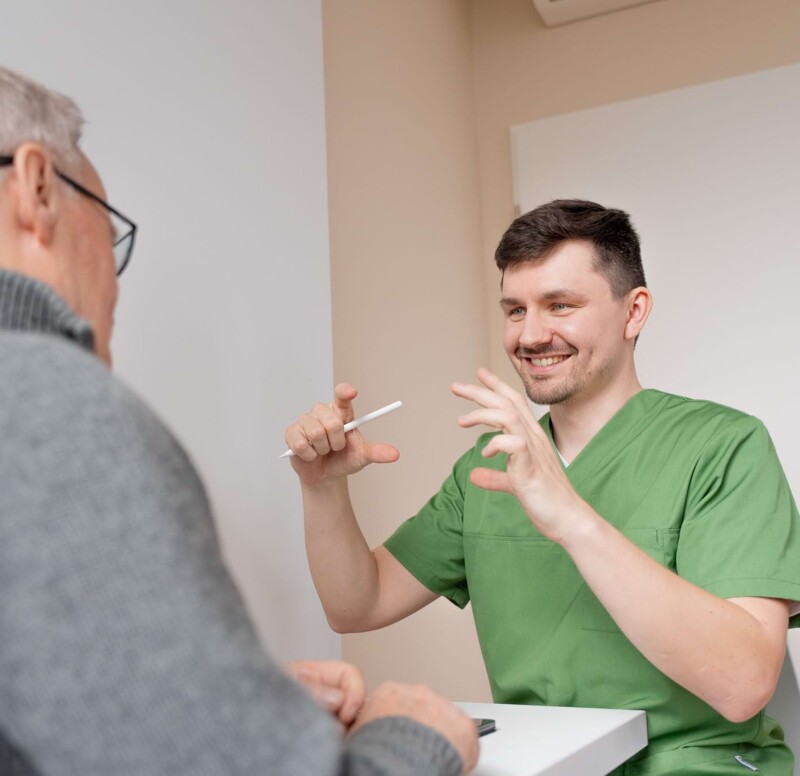 Fotoaufnahme: Zahnarzt Schwenn erklärt einem Patienten einen Vorgang