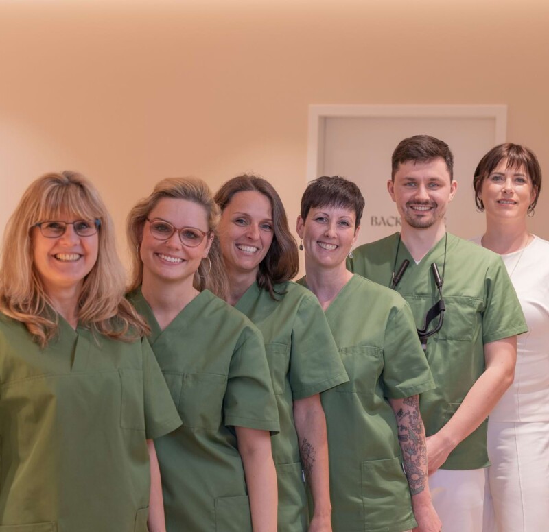 Fotoaufnahme: Team steht aufgereiht und schaut in die Kamera