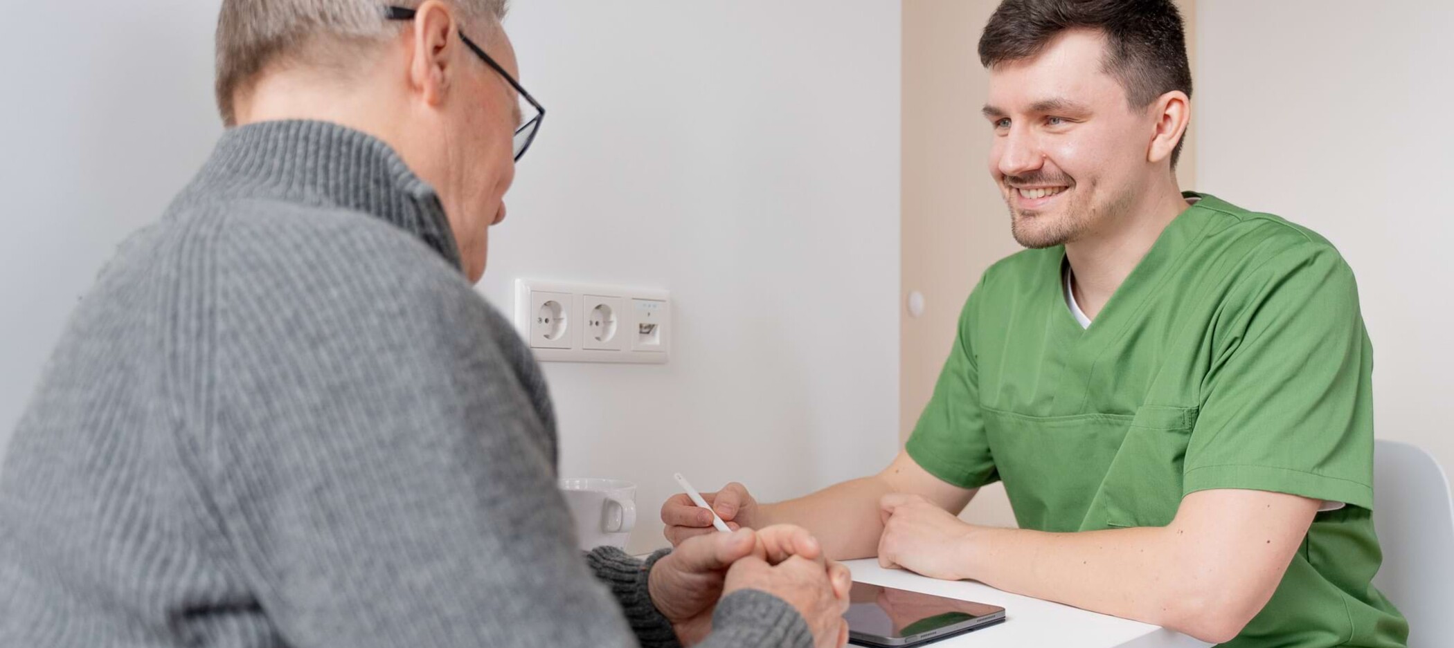 Fotoaufnahme: Christopher Schwenn im Beratungsgespräch mit Patient